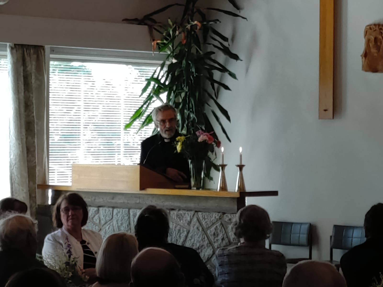 Entinen kirkkoherra Pekka Rantala puhuu seurakuntakodin puhujankorokkeelta