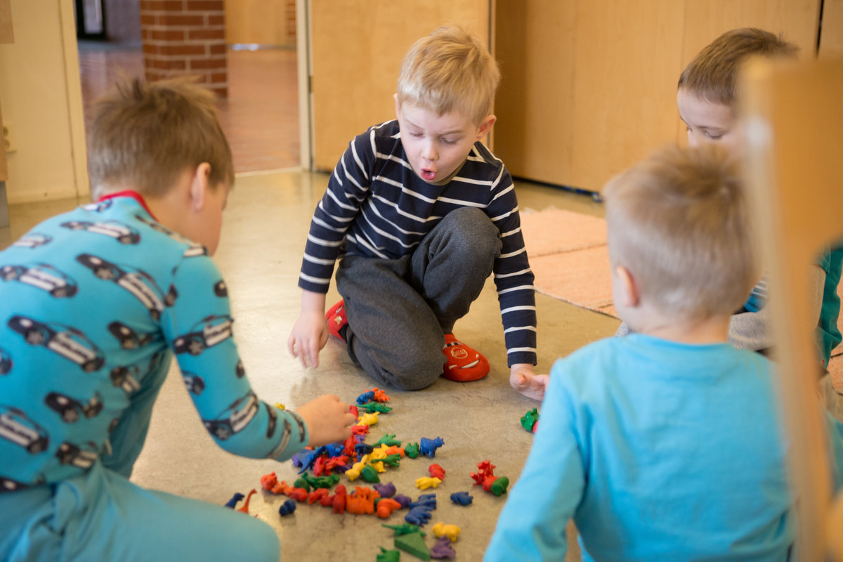 lapsia leikkimässä lattialla leluilla seurakunnan kerhossa