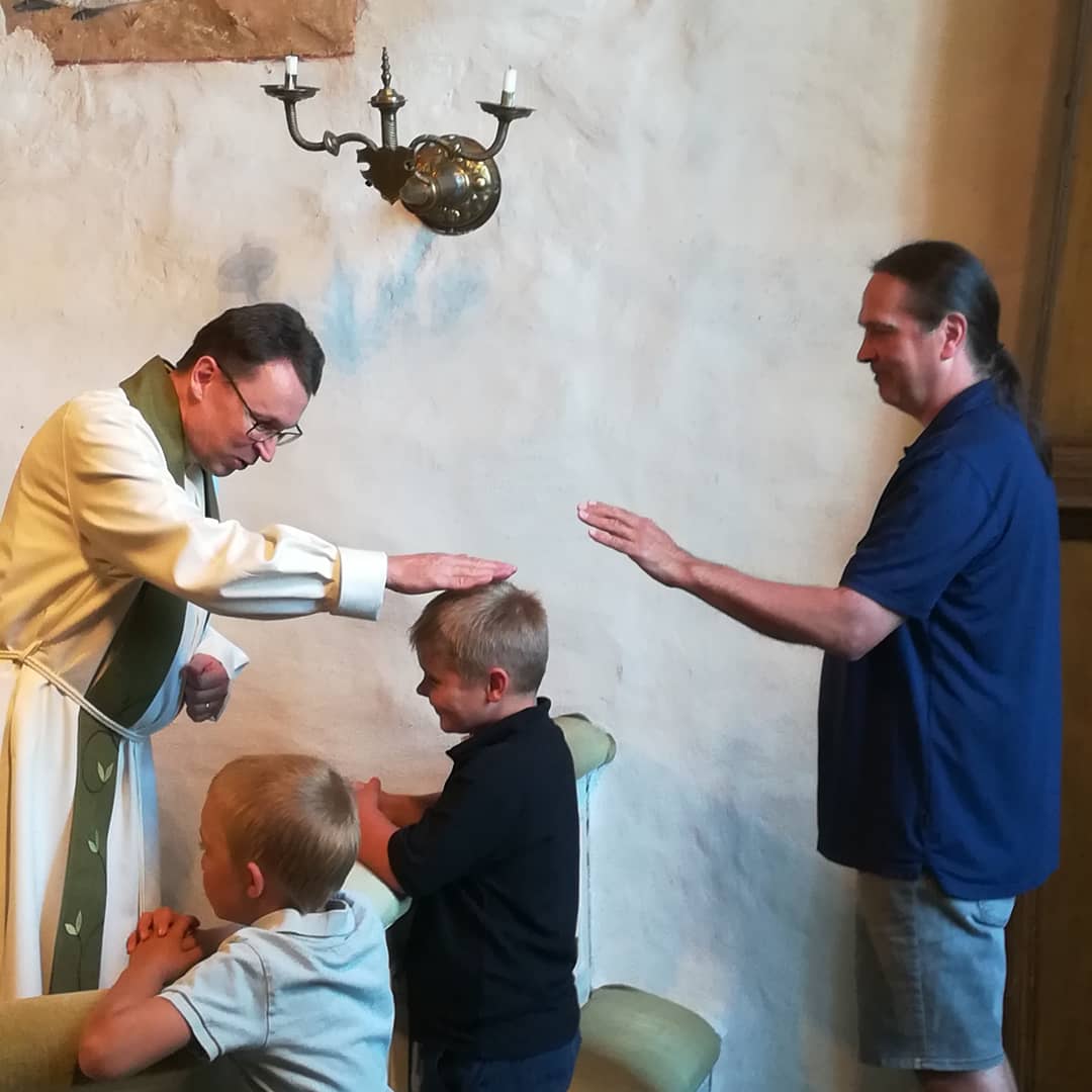 Kummi ja pappi siunaavat pienen koululaisen alttarilla Kalannin kirkossa